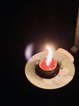 暗闇に浮かぶ一輪の炎と陶器の灯皿の灯り 炎,火,灯りの写真素材