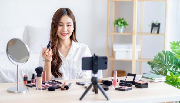 化粧品をネット配信で紹介する若い女性 化粧品をネット配信で紹介する若い女性の写真