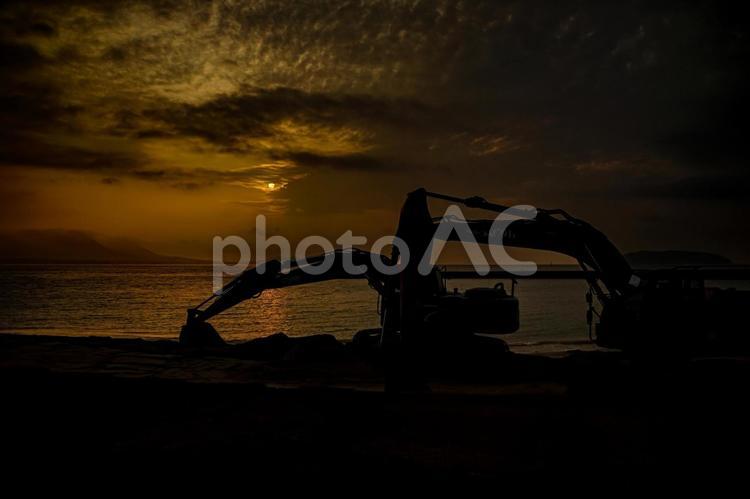 ＜素材＞夜明けの砂浜整地用のショベルカー 重機,油圧ショベル,ショベルカーの写真素材