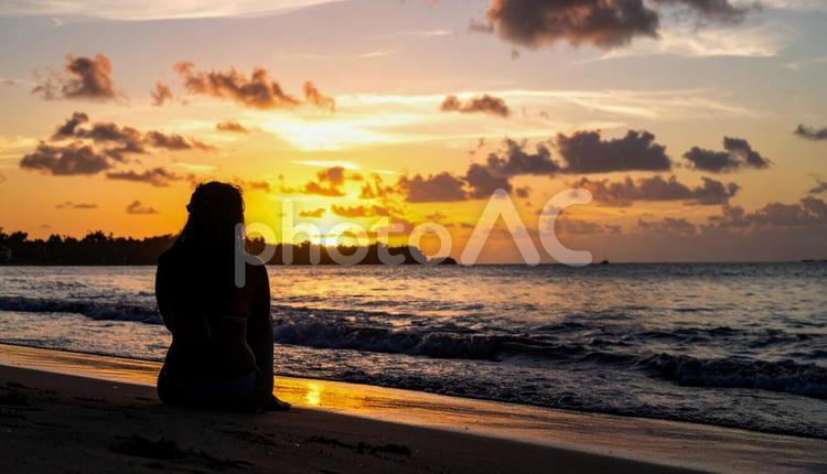 夏の終わりの海岸で 人物,女性,夕陽の写真素材
