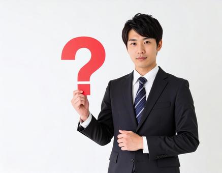 クエスチョンマークのオブジェを持つ男性 クエスチョンマークのオブジェを持つ男性の写真