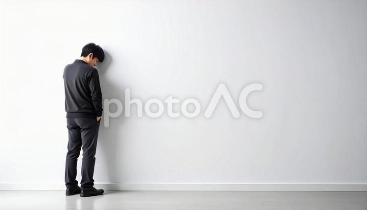 壁に寄りかかる落ち込んでいる日本人男性 男性,落ち込み,自信喪失の写真素材
