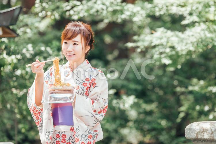 夏祭りで焼きそばを食べる浴衣姿の女性 焼きそば,縁日,夏祭りの写真素材