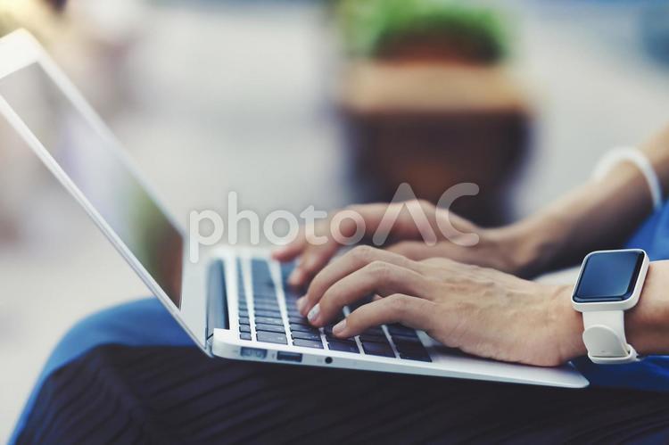 屋外でラップトップを使用する人物の手元クローズアップ 背景ぼかし パソコン,ラップトップ,ノートパソコンの写真素材