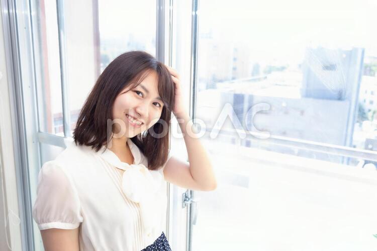窓際に立つ笑顔の女性 窓際に立つ笑顔の女性 女性,笑顔,笑うの写真素材