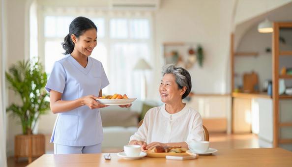 笑顔で食事を運ぶ女性介護士と高齢女性 笑顔で食事を運ぶ女性介護士と高齢女性の写真