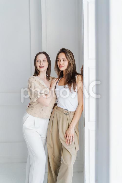 室内でくっついて立っている2人の女性 女性たち,女性,外国人の写真素材