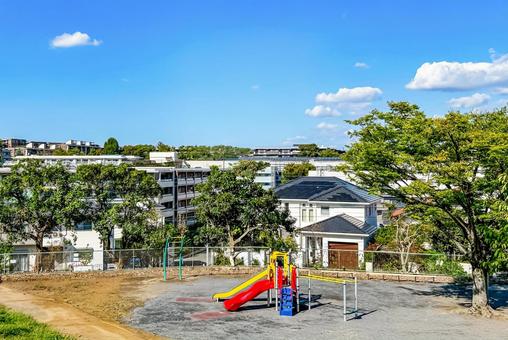 すべり台のある高台の公園と広がる街並み 公園,緑,街並みの写真素材