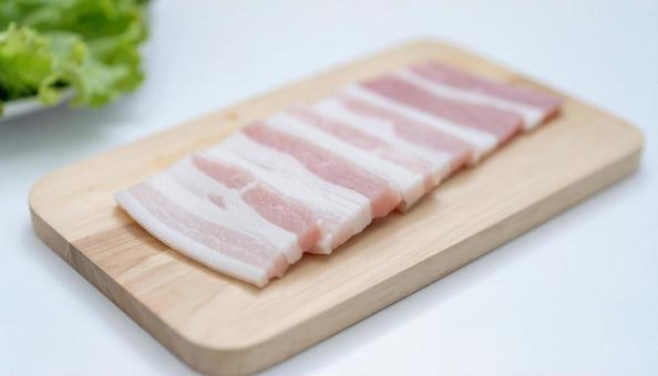 カッティングボードの上の豚バラ肉 カッティングボードの上の豚バラ肉の写真