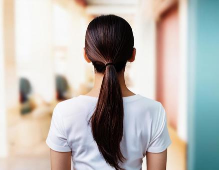 まとめ髪の白いTシャツを着た女性 まとめ髪の白いTシャツを着た女性の写真