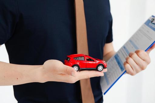 手のひらに赤い車を持つ男性の手元 保険業,事務職,接客業の写真素材