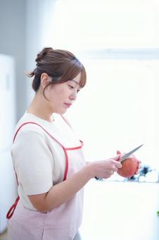 リンゴの皮むきをする女性 女性,真剣,横向きの写真素材