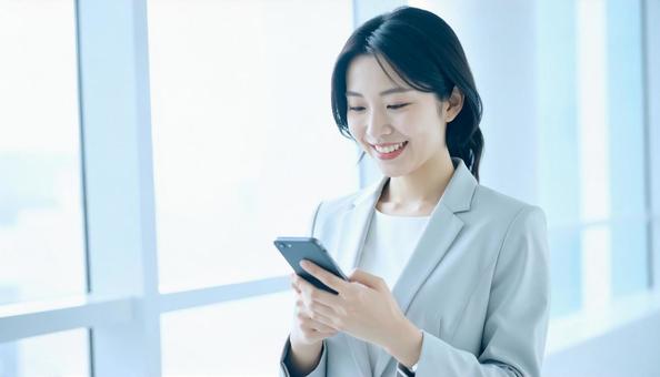 スマホを確認するビジネス女性 スマホを確認するビジネス女性の写真