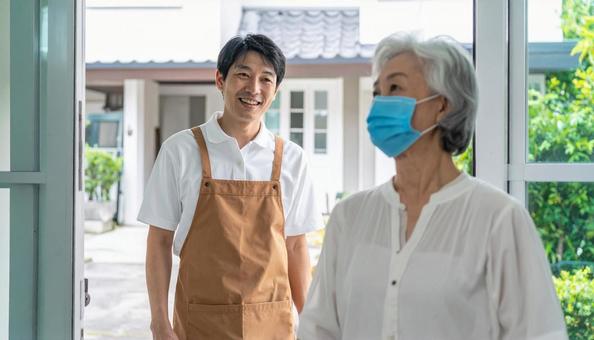 見守り訪問で高齢者住宅を訪問する男性 見守り訪問で高齢者住宅を訪問する男性の写真
