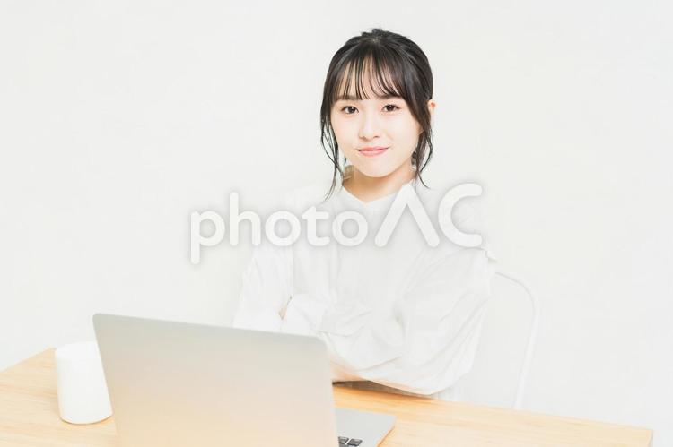 PCの前で腕組みしている笑顔の若い女性 パソコン,腕組み,笑顔の写真素材