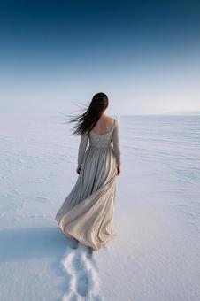 雪原を歩く女性の後ろ姿 雪原を歩く女性の後ろ姿の写真