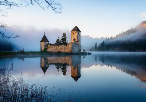 朝霧に包まれた湖畔の古城廃墟 朝霧に包まれた湖畔の古城廃墟の写真