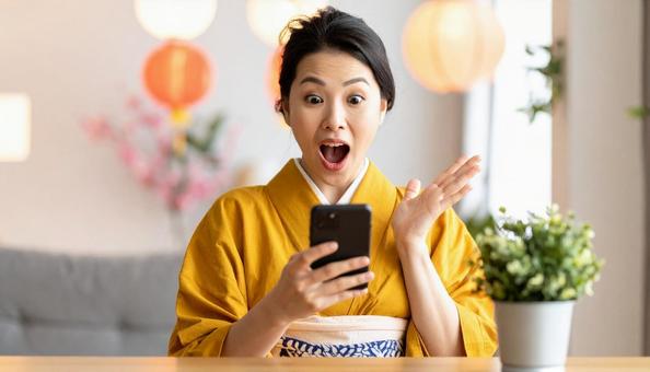 携帯電話を見て驚いている女性 携帯電話を見て驚いている女性の写真