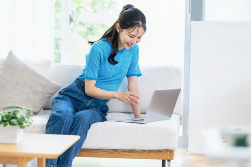 パソコンを操作する女性 女性,笑顔,ノートパソコンの写真素材