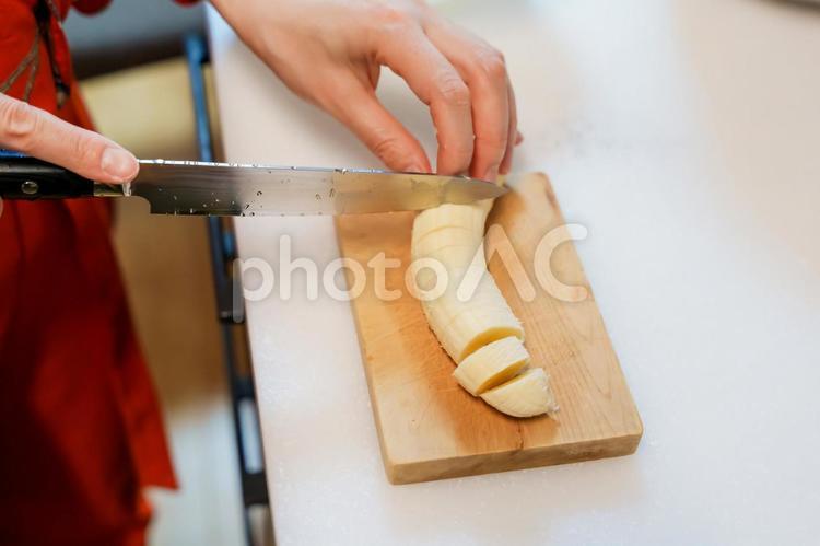 バナナを包丁で切る手元 バナナ,切る,まな板の写真素材