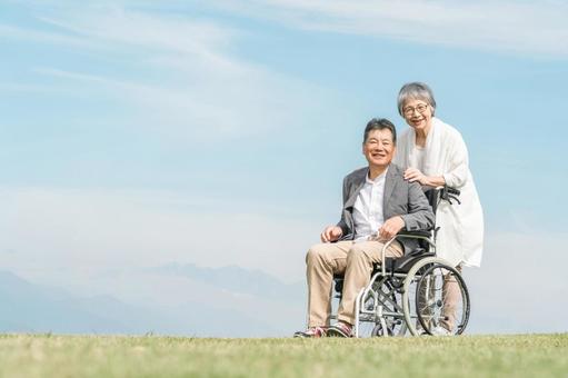 公園で車椅子に乗って散歩する高齢者夫婦 福祉,介護,高齢者の写真素材