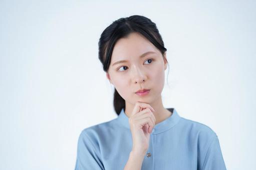 女性が顎に手を当てて考える 女性,考える,困るの写真素材