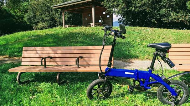 公園のベンチと小型電動バイク 青色,緑,特殊原動機付自転車の写真素材