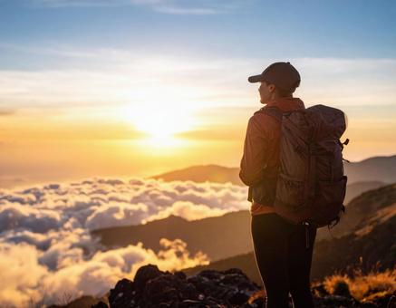 山頂から景色見る男性の後ろ姿の写真