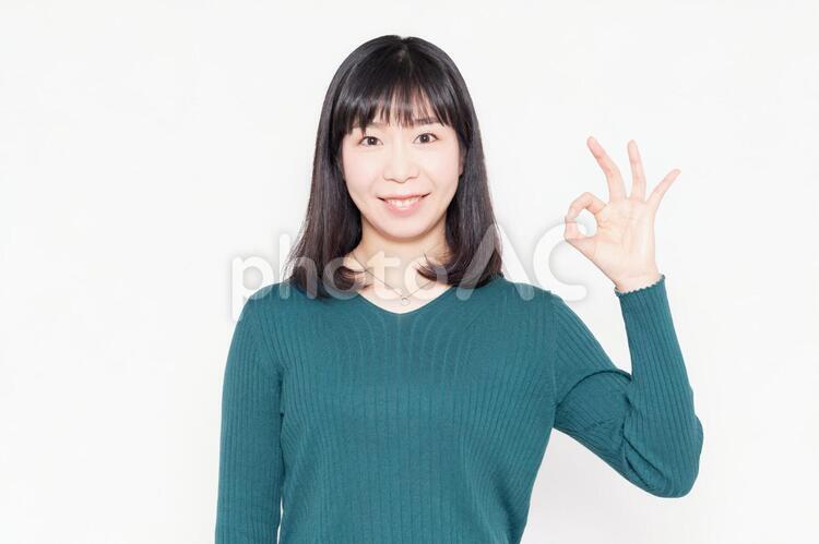 白背景の前に立ってOKのジェスチャーをする女性 女性,ビジネス,okの写真素材