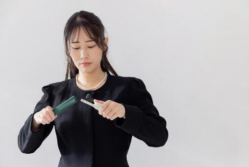 お葬式イメージ　線香に火を付ける女性 葬儀,葬式,女性の写真素材
