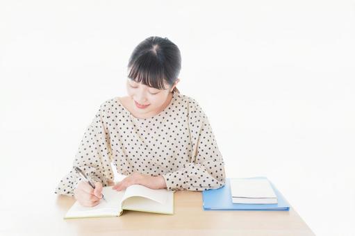机で勉強をする若い女性 入試,教科書,テストの写真素材