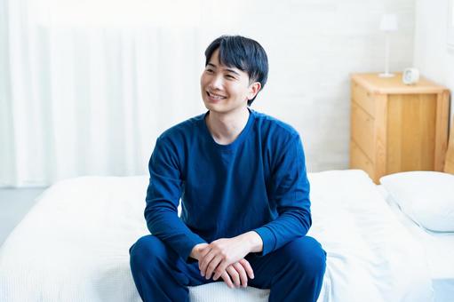 ベッドで笑顔の男性 アジア人,家,室内の写真素材