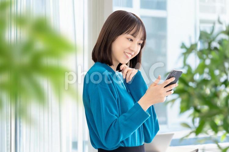スマホを使う笑顔の女性・ビジネスウーマン 女性,ビジネス,スマホの写真素材
