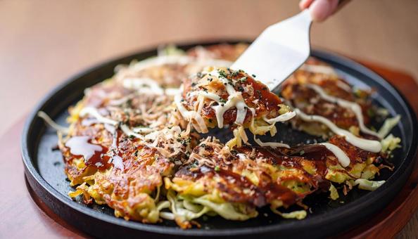 お好み焼きを鉄板で焼く お好み焼きを鉄板で焼くの写真