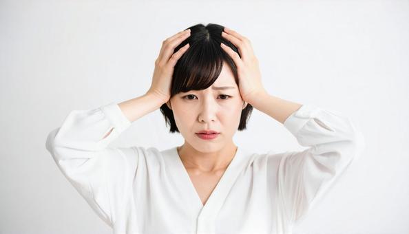 頭を抱えて悩む表情の女性 頭を抱えて悩む表情の女性の写真