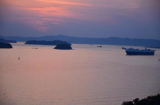夕暮れの瀬戸内海を進む大型貨物船と島影 夕焼け,海,空の写真素材
