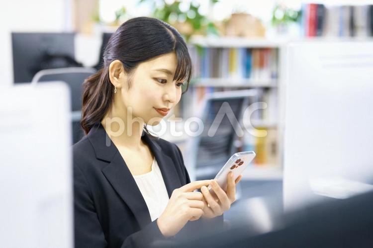 スマホ　キャリアウーマン　デスクワーク スマホ,ビジネスウーマン,ビジネスシーンの写真素材