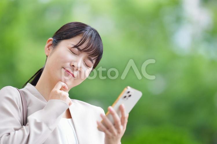 携帯を見て考える女性 女性,人物,大学生の写真素材