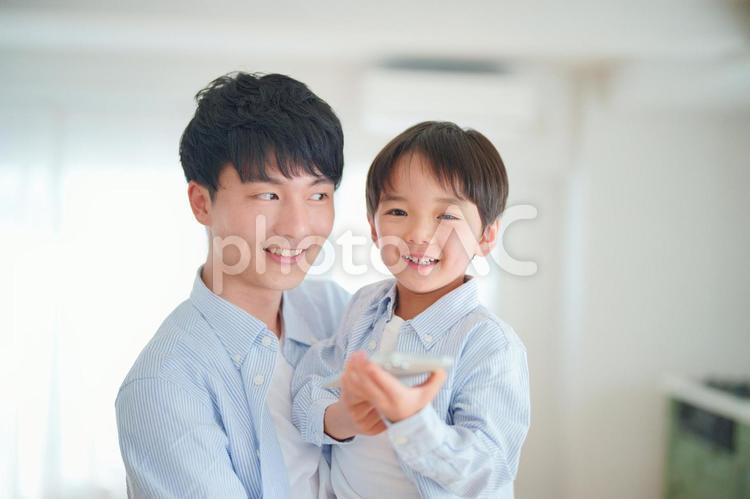 スマートフォンを使っている男の子を抱っこしているお父さん 親子,父子,お父さんの写真素材