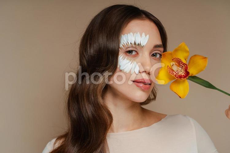黄色の花を持つフラワーメイクの女性 女性,シンビジウム,黄色の写真素材