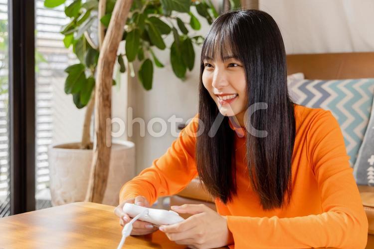 テレビゲームを楽しむ若い女性　お家時間 女性,ライフスタイル,日本人の写真素材