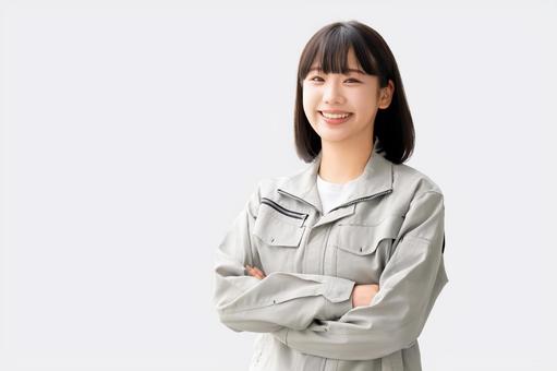 作業服を着て腕組みをする若い女性 作業服を着て腕組みをする若い女性 女性,ビジネス,作業服の写真素材