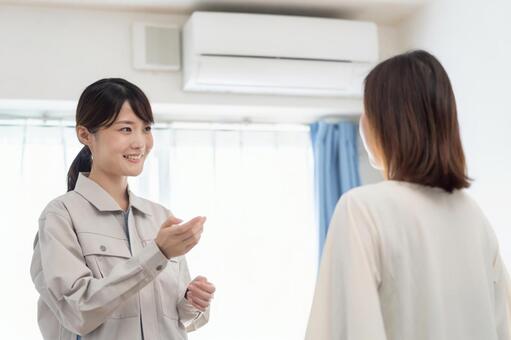 エアコンの説明をする女性の作業員 女性,エアコン,クーラーの写真素材