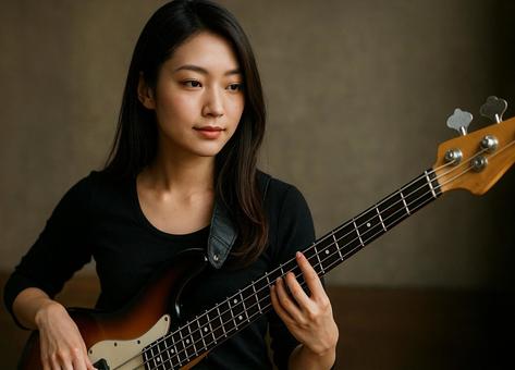 ベースを弾く女性ミュージシャンの横顔の写真