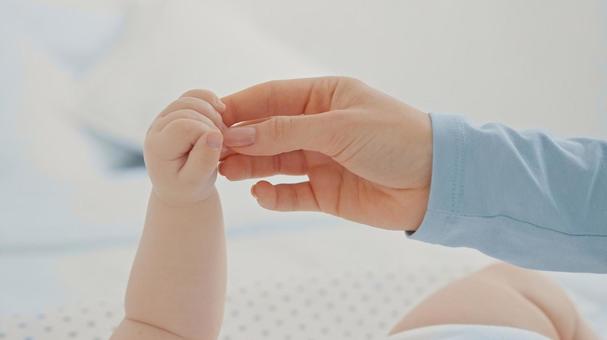 大人の指先を掴む赤ちゃんの手 大人の指先を掴む赤ちゃんの手の写真