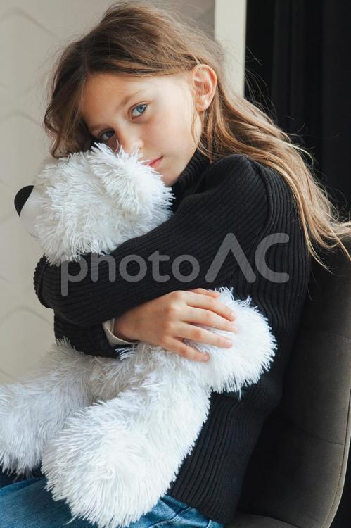 カメラ目線でぬいぐるみを抱いている女の子 ぬいぐるみ,シロクマ,抱きしめるの写真素材