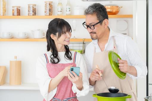 キッチンで料理を作るミドルの夫婦 キッチンで料理を作るミドルの夫婦 料理,夫婦,ミドルの写真素材