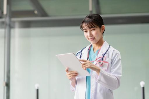 タブレットを操作する若い女性医師 タブレットを操作する若い女性医師 若い,医師,女性の写真素材