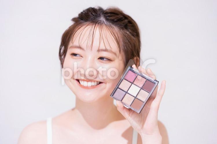 コスメアイテムを持つ若い女性 女性,美容,化粧の写真素材