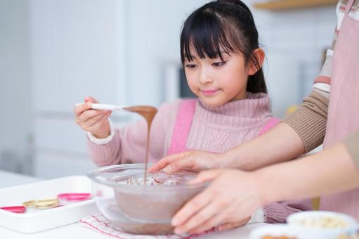 スイーツ作りに夢中な女の子の笑顔 女の子,チョコレート,ヘラの写真素材